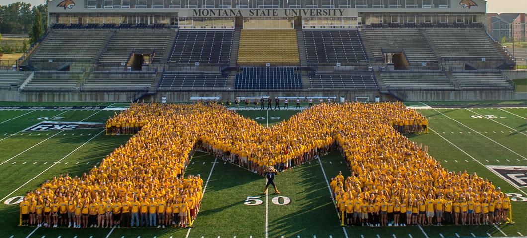 The class photo on the football field in the shape of an M.