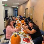 Students carving pumpkins at the 2022 AIC Halloween Party