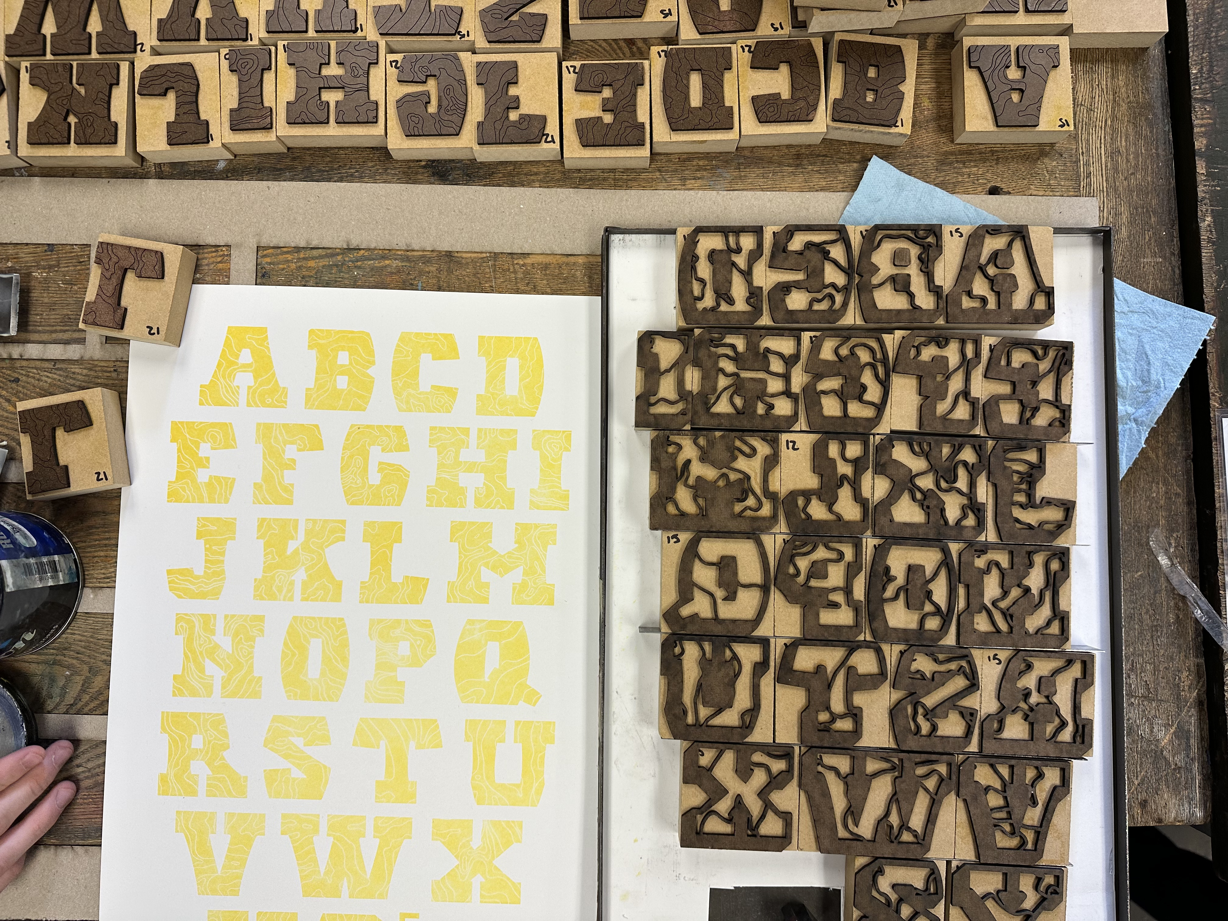 Laser cut letterforms printed in yellow ink. 