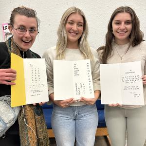 Students display their type specimen books created with metal type. 