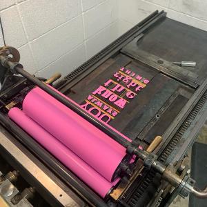 Hot pink ink on with type set in the letterpress. 