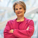 Portrait of a woman in front of a light background.