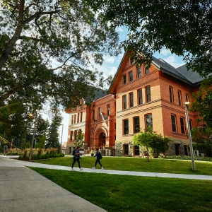 The sun rises over Wilson Hall at Montana State University on the left, while Montana Hall bathes in sunlight on the right side of the image during fall 2019.