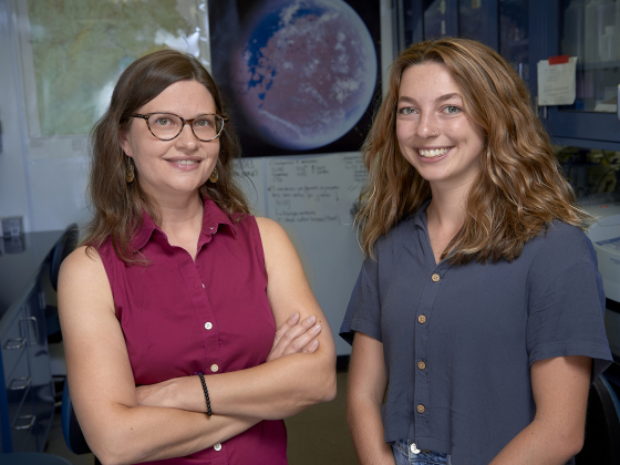 Erica Antill and Alexis McDonnell standing together in a lab with a poster of Mars in the background | MSU photo by Kelly Gorham