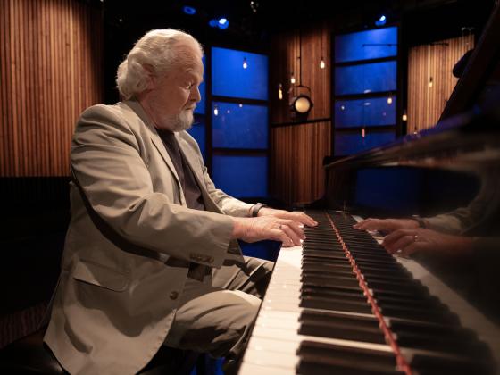 Eric Funk playing piano on a TV set. | MSU photo by Kelly Gorham