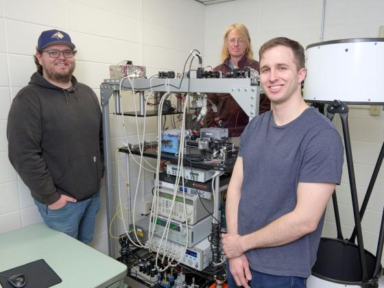 Three men stand around a large technology array while looking at the camera | MSU photo by Colter Peterson