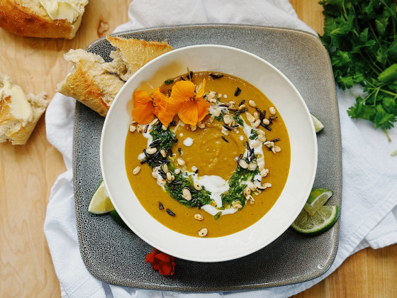 A soup in a bowl with crusty bread on the side. | 