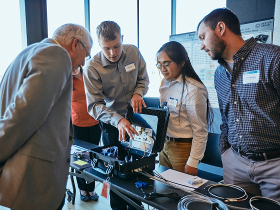 A group of people looking at a mechanical device | MSU photo by Adrian Sanchez-Gonzales