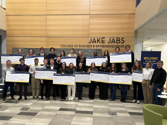 Students who made the finals of the annual Big Idea Challenge hold oversized checks. | 