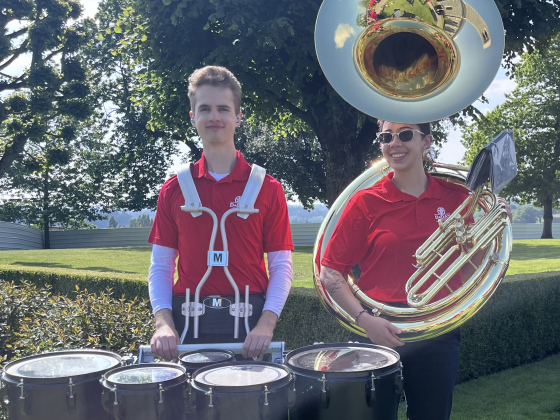 Two MSU marching band students, Jackson Queneau and Jackie Olivares, pose for a phot with their instruments, tenor drums and a sousaphone, during the 80th anniversary of D-Day in Normandy, France. | 