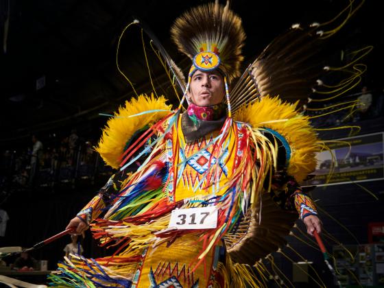 A dancer in traditional Native American regalia dancing