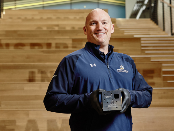 Brock LaMeres holding a small metal cube | MSU photo by Adrian Sanchez-Gonzalez