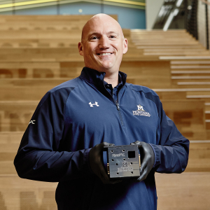 Brock LaMeres holding a small metal cube