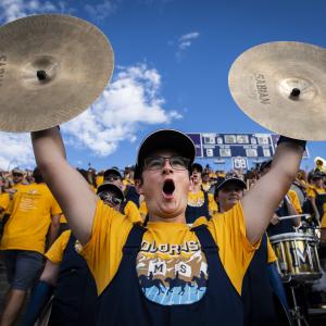 marching band student with cymbals cheering