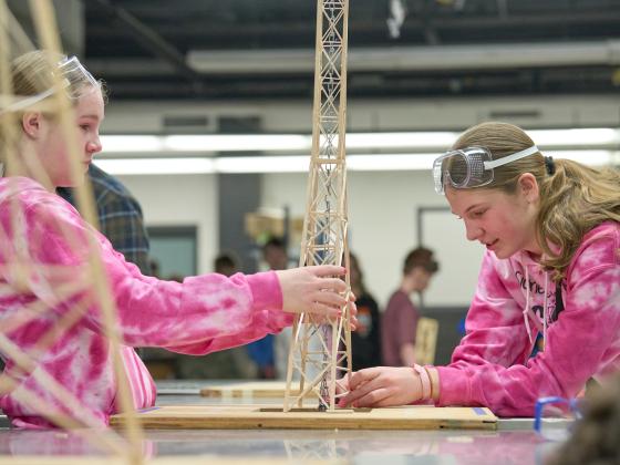 Two elementary students setting up a model bridge