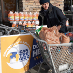 People loading food into a shopping cart