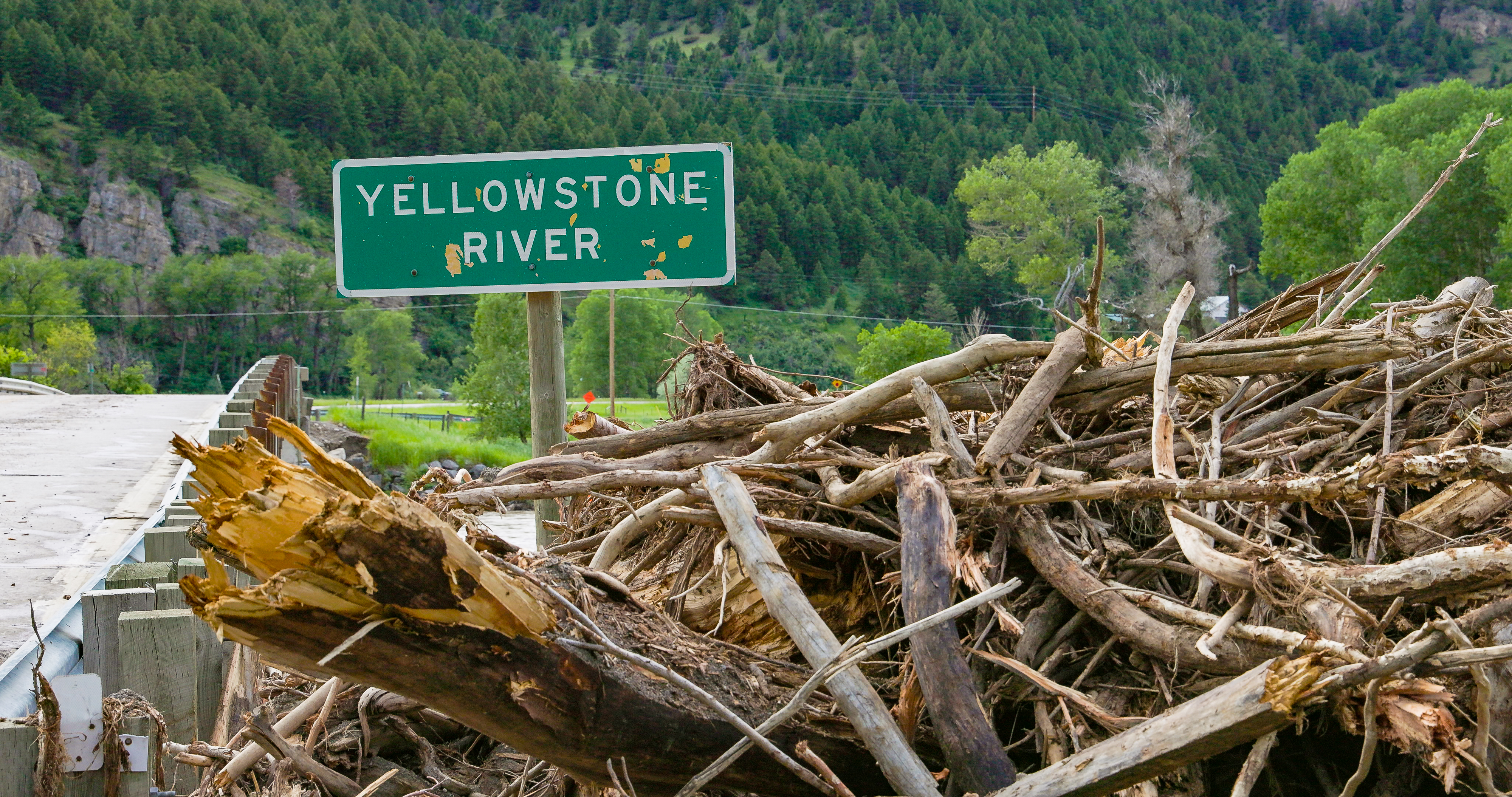 Sign reading Yellowstone River next to the Yellowstone River.