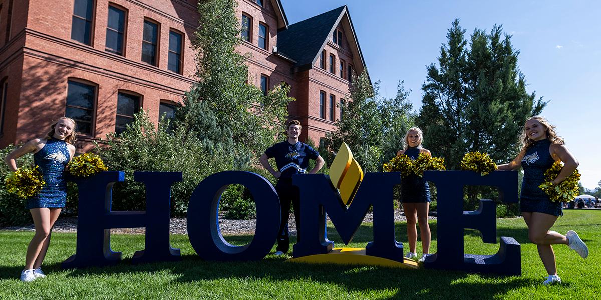 MSU cheerleaders behind letters spelling HOME