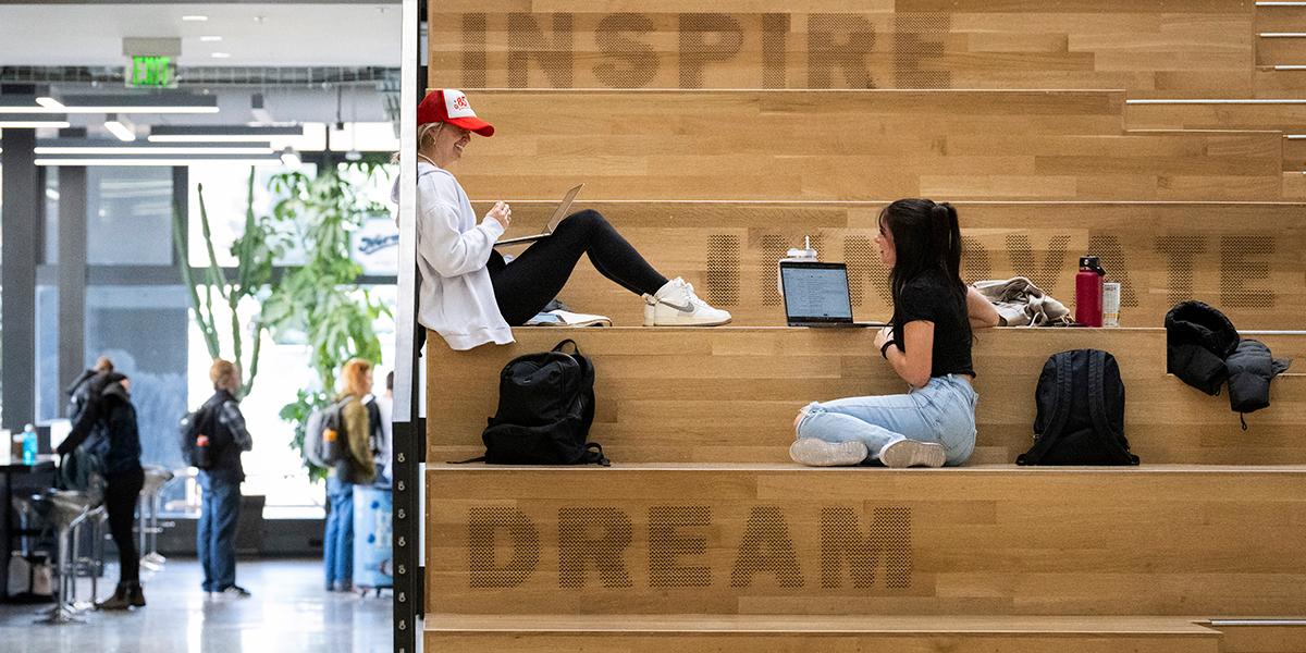 Two students chatting while working on school work