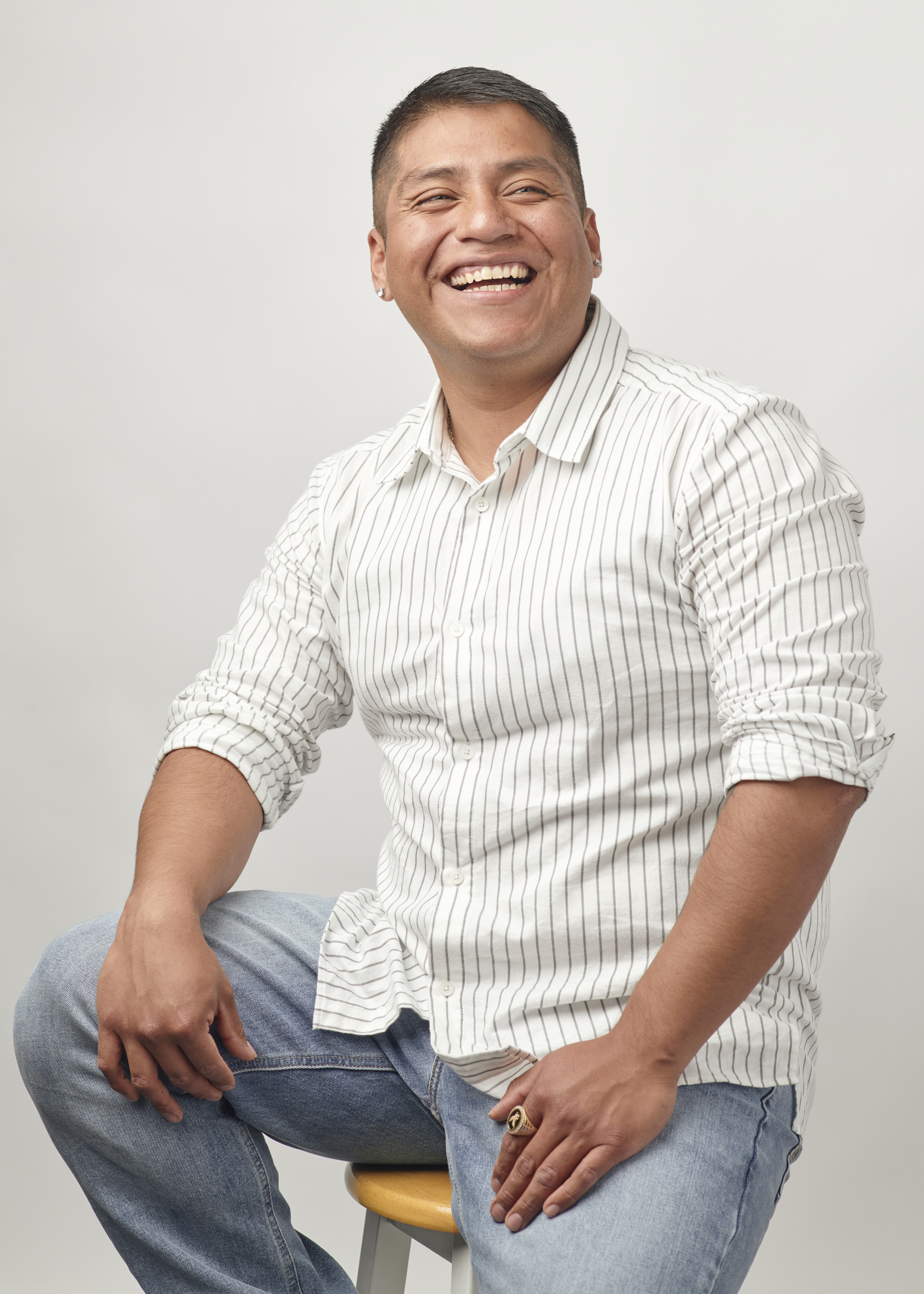 Pablo Santibanez is pictured, sitting on a stool and smiling.