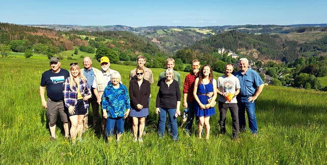 A group of people with a ninth-century castle in the background and millions of acres of dying Norway spruce.