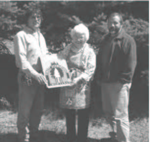Old, Black and white image of Mary Naegeli and two men holding the scholarship award.