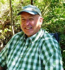 Image of peter kolb with a tan hat and blue and green checkered shirt.