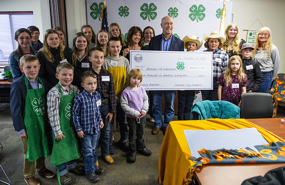 4-H youth members stand with Governor Gianforte and a gift check