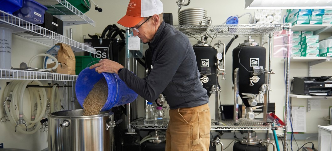 Man in brewing lab pouring barley