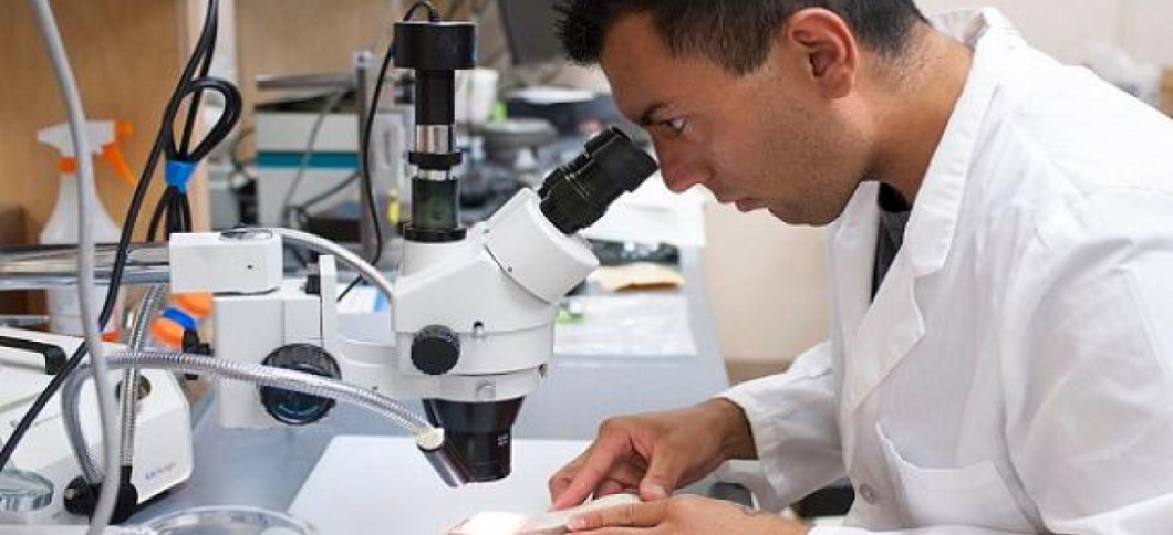 man in labcoat with microscope