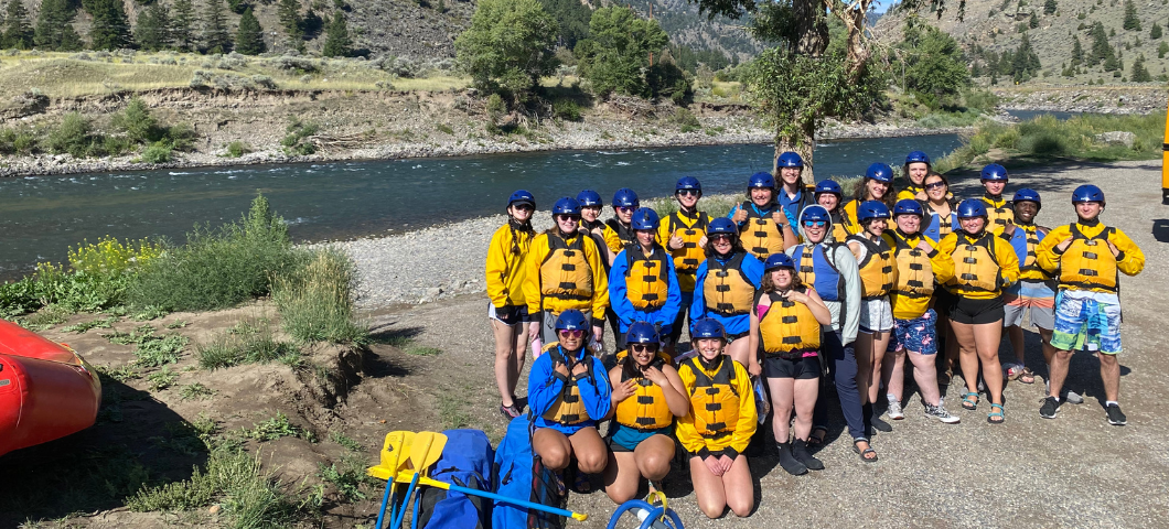 TRIO Scholars posing for a group picture in lifejackets in front of a river