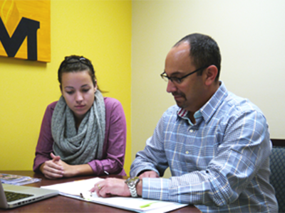 student sitting with an instructor at a computer